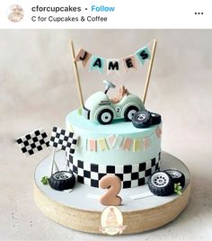 a cake decorated with cars and bunting flags on top of a wooden stand that says james for cupcakes & coffee