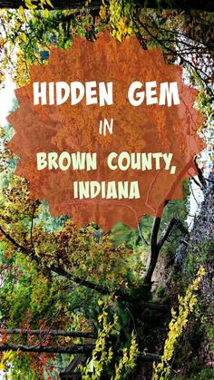 the hidden gems in brown county, indiana sign is surrounded by autumn foliage and trees