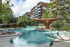 an outdoor swimming pool surrounded by trees and buildings