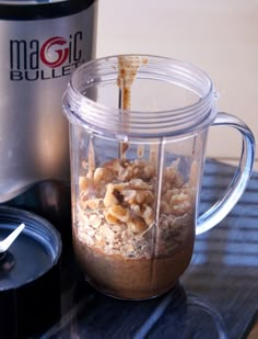 a blender filled with oatmeal sitting on top of a glass table