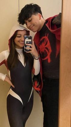 a man and woman taking a selfie in front of a mirror wearing bodysuits