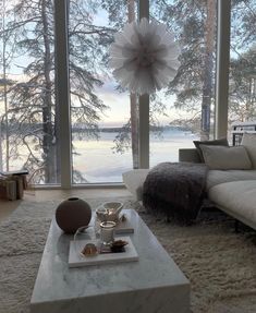 a living room filled with lots of furniture and large windows overlooking the snow covered lake