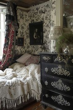 a bedroom with floral wallpaper and an old dresser