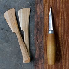 two wooden knives and a knife block on a table