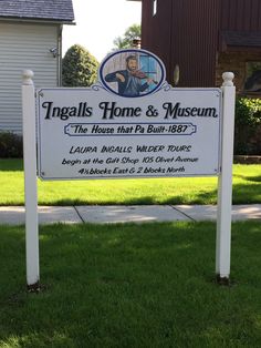 a sign for the home and museum in front of a white house with a man on it