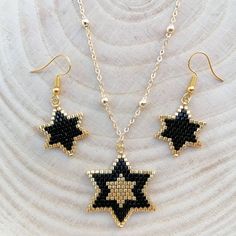 a necklace and earring set made out of seed beads with black and white stars