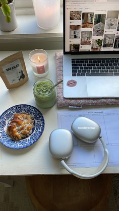 a laptop computer sitting on top of a desk next to a plate with food in it