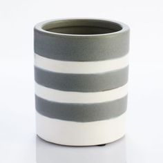 a grey and white striped vase sitting on top of a table