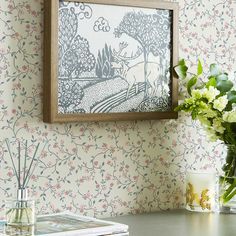 a vase filled with flowers sitting on top of a table next to a wall paper