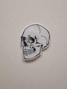 a white sticker with a black and white skull on it's face, in the shape of a human head