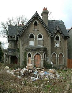 an old house with lots of trash in front of it