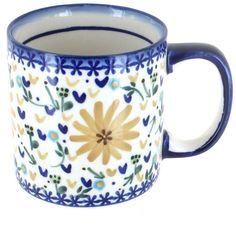 a blue and white coffee cup with yellow flowers on the inside is sitting in front of a white background