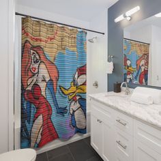 a bathroom with two shower curtains and a painting on the wall behind the sink area