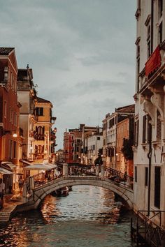 a small bridge crossing over a river between two buildings