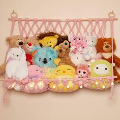 a group of stuffed animals sitting on top of a pink shelf