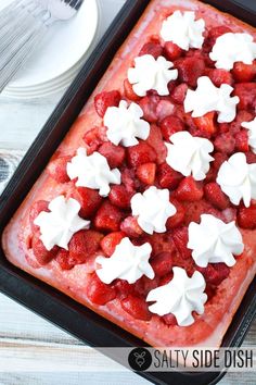 strawberry shortcakes with whipped cream on top in a baking pan, ready to be eaten