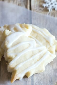 two cookies with white icing sitting on top of a wooden table