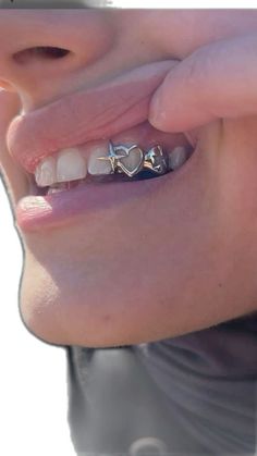 a close up of a person's teeth with braces and piercings on them