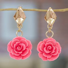 pink flower earrings hanging from a branch