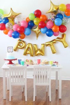 a party table with balloons and decorations