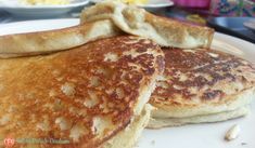 two pancakes on a white plate with butter and syrup in the middle one has been cut into pieces