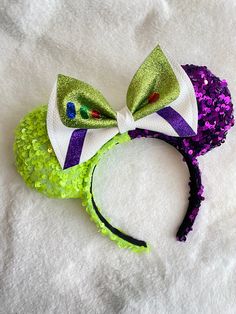 a green and purple minnie mouse ears with sequins