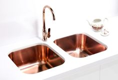 two copper colored sinks in a white kitchen