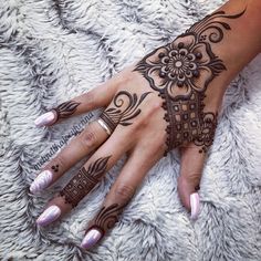 a woman's hand with henna tattoos on it