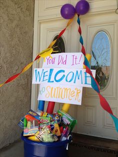 a welcome to summer sign in front of a door with balloons and streamers around it