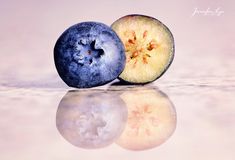 two pieces of blueberry sitting next to each other on top of a reflective surface