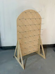 a wooden chair sitting on top of a floor next to a white wall with wires attached to it