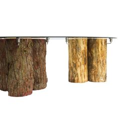 three wooden logs are hanging from a glass table with metal bars on each end and one is holding two cans