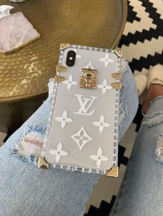 a cell phone case sitting on top of someone's legs in ripped denims