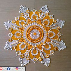 an orange and white paper doily on a wooden surface