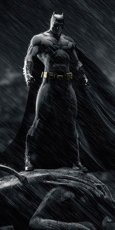 the dark knight is standing in the rain