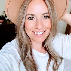 a woman wearing a brown hat smiling for the camera