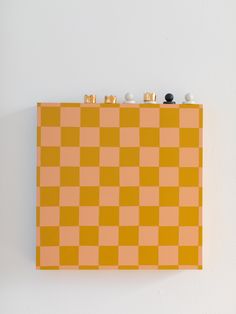 an orange and yellow checkered board with three black knobs on it's sides