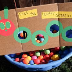 a cardboard box filled with lots of different colored candies in the shape of a caterpillar