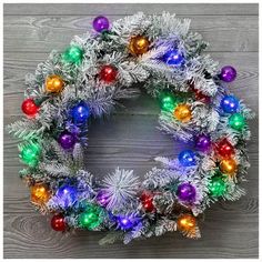 a christmas wreath with multicolored balls and tinsel