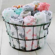 a basket filled with lots of different types of baby swaddles in various colors