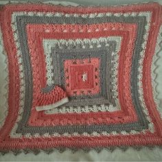 a crocheted square is displayed on a bed