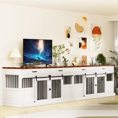 a flat screen tv sitting on top of a white entertainment center in a living room