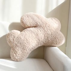 a teddy bear is laying on the back of a couch cushion that has been made into a pillow