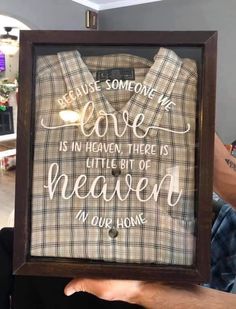 someone is holding up a framed shirt that says, because someone we love is in heaven there is little bit of heaven in your home