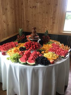 a table topped with lots of different types of fruit on top of a white table cloth