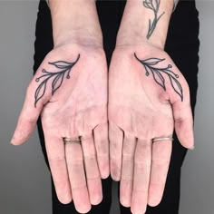 two hands with tattoos on them are holding each other's palms and their fingers