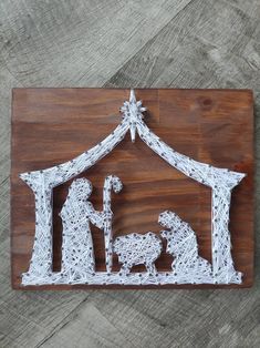 the nativity scene is made out of string and wood, with a star above it