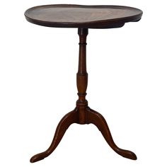 a small wooden table with two legs and a circular top on an oval pedestal,