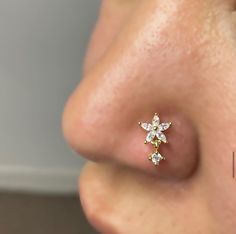 a close up view of a nose with a small diamond flower on it's side