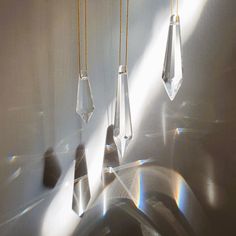 three crystal hangings on the side of a white wall next to a kitchen sink